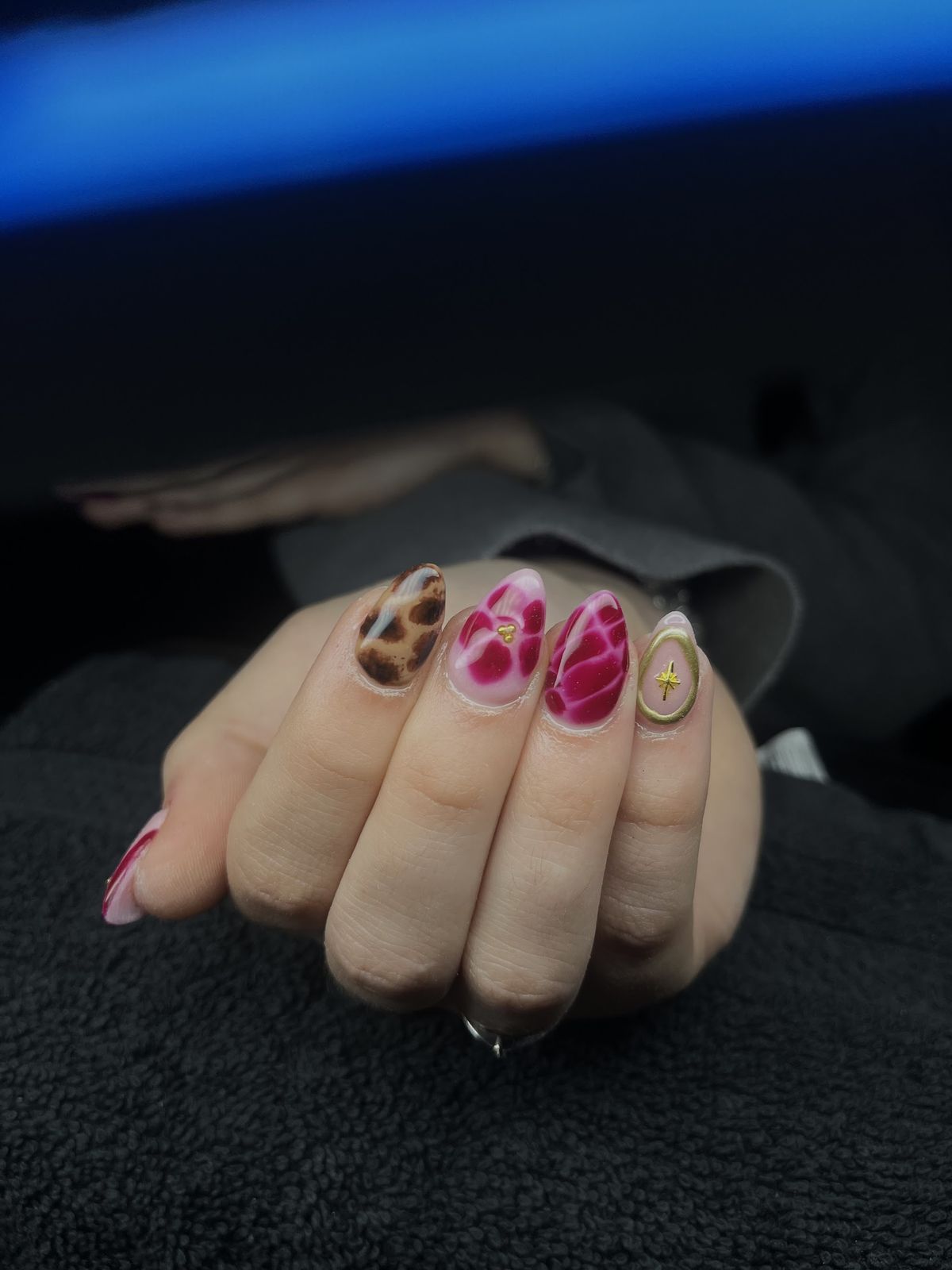 Amandelnagels met luipaardprint, roze en rood marmer en een gouden ster