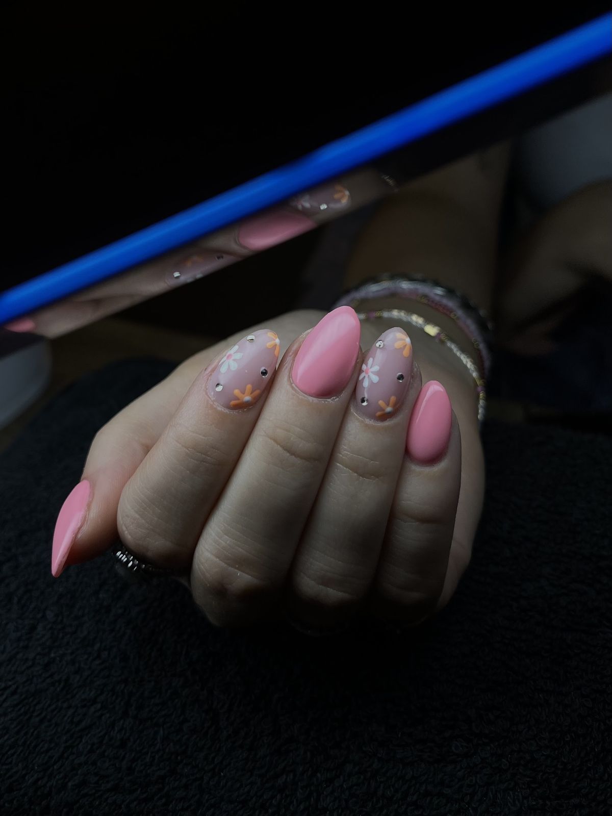 Roze amandelnagels met gouden accenten en armbandjes
